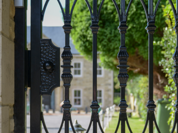 Black Iron Gate Lock - set on a manicured estate.